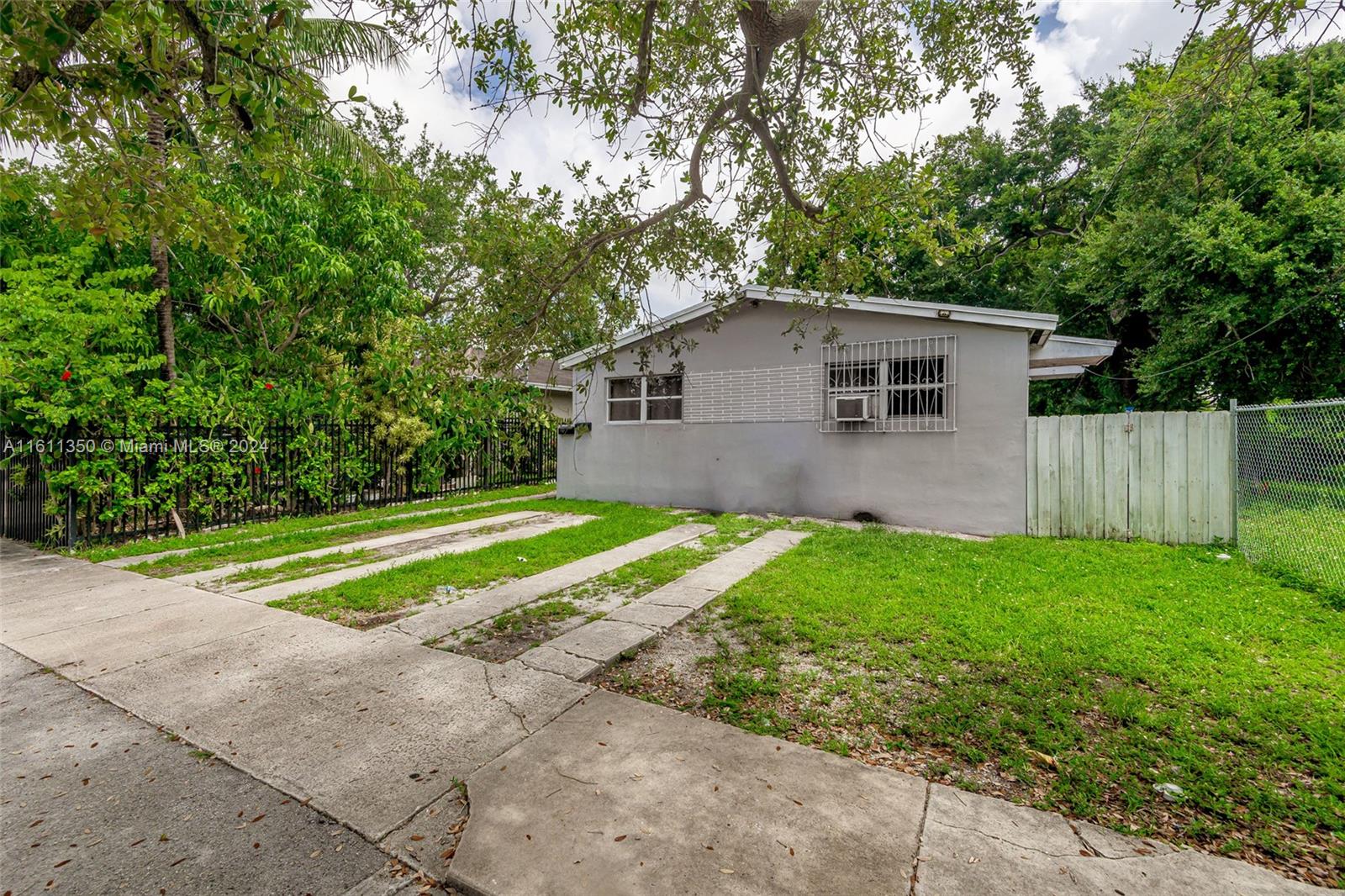 a view of a house with a yard and a large tree