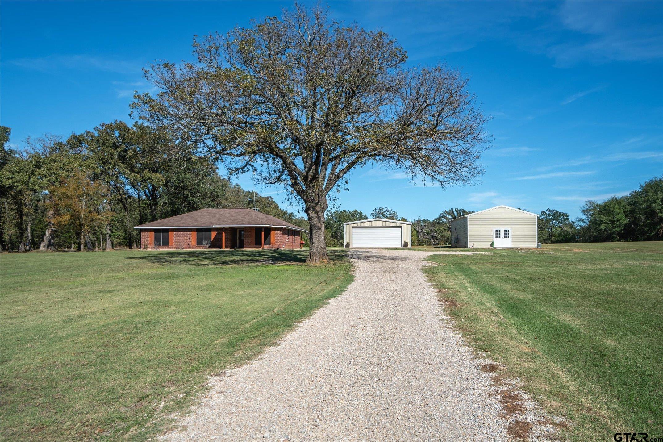 a front view of a house with a yard and trees