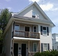 a view of small house with large windows and a small yard