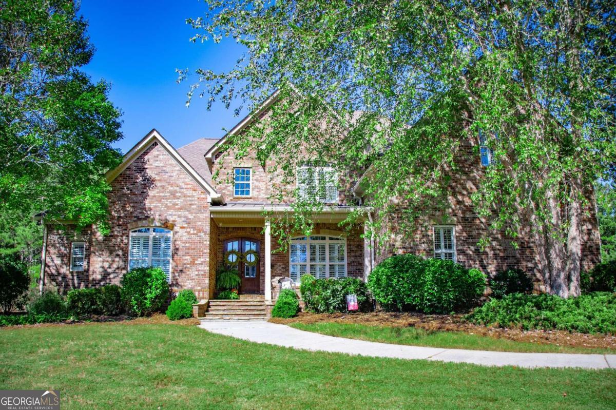 a front view of a house with a yard and green space