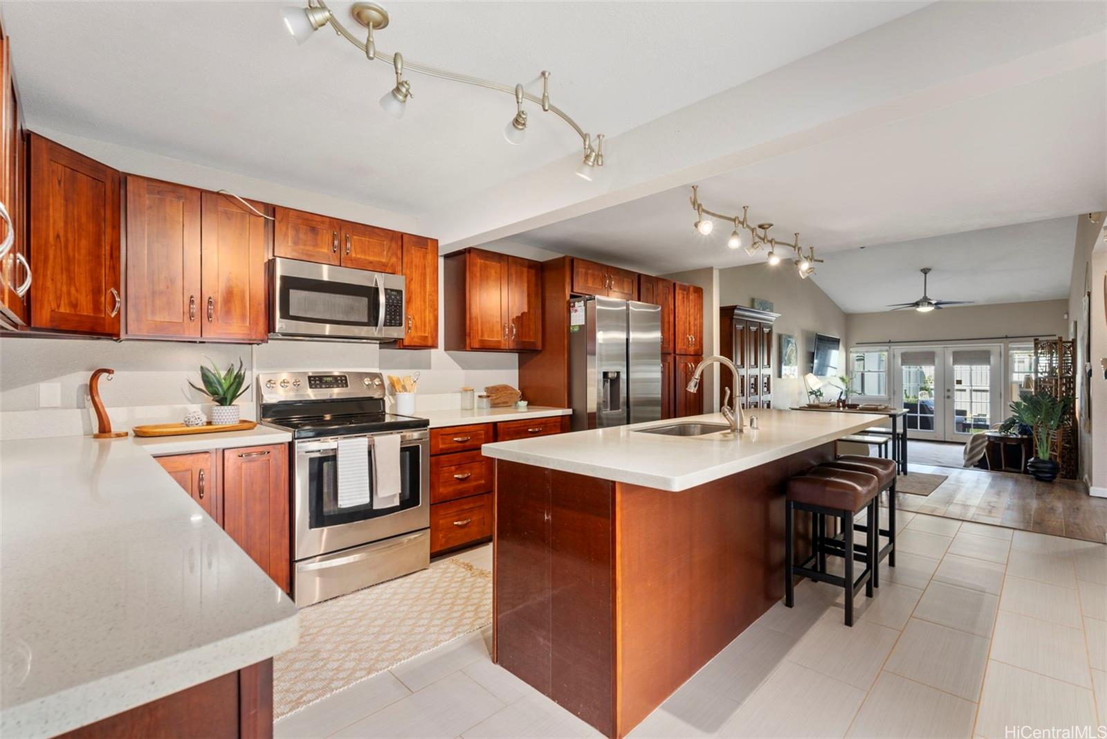 a kitchen with kitchen island granite countertop a stove top oven a sink a counter top space and cabinets