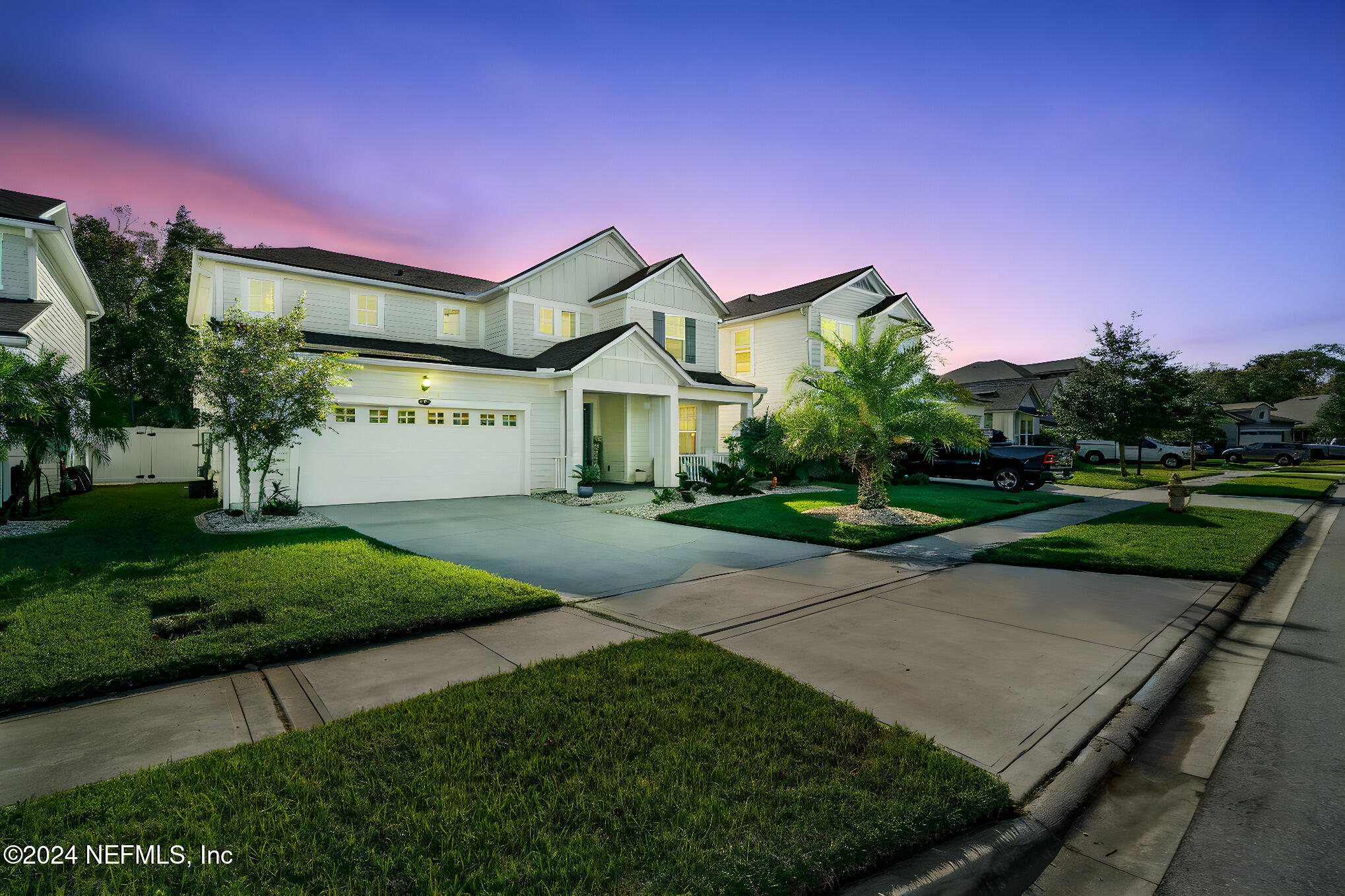 a front view of a house with a yard and green space