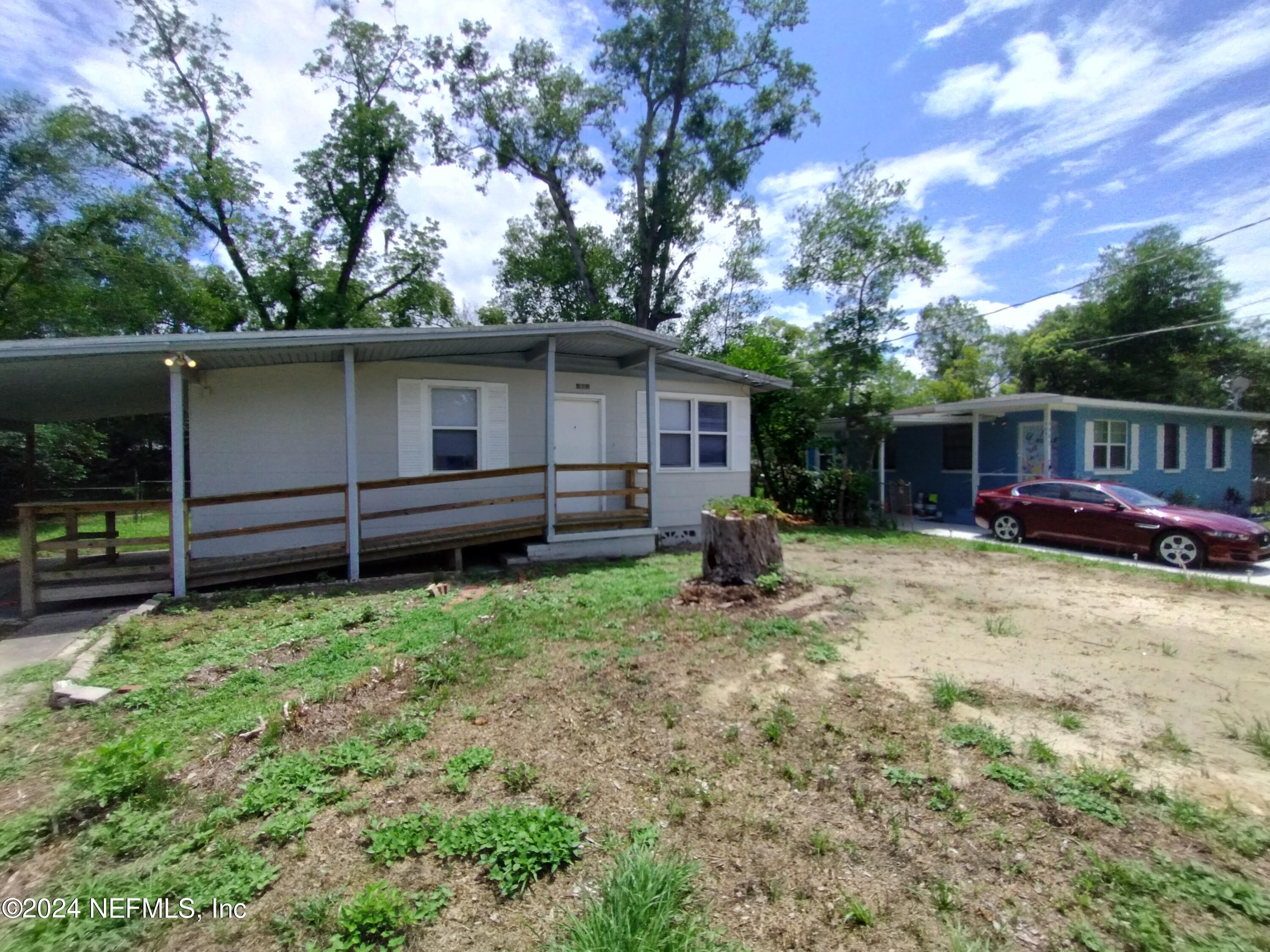 a backyard of a house with barbeque oven and table and chairs