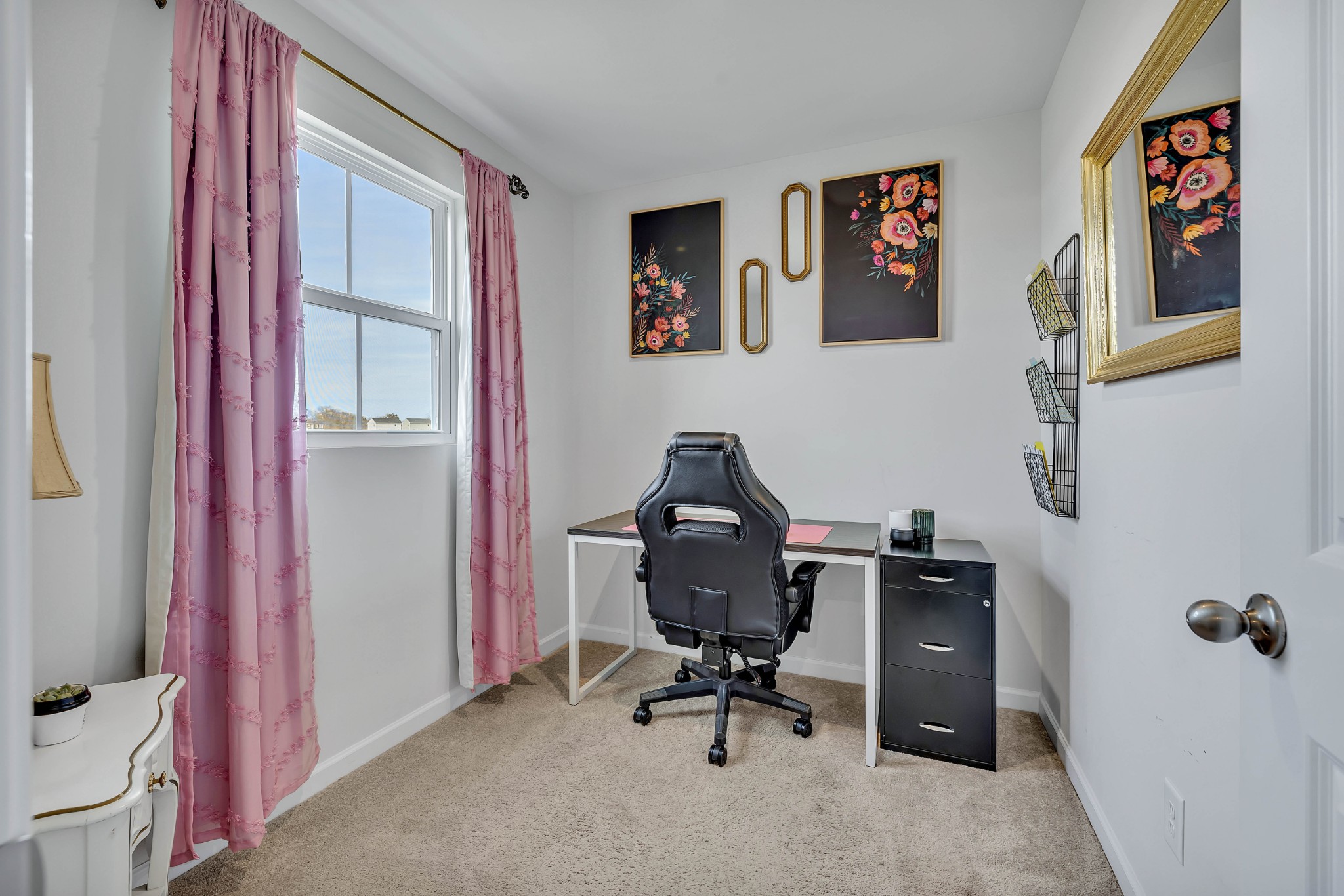 a view of a workspace with furniture and a window