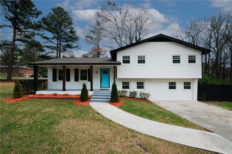 a view of a house with a yard and sitting area