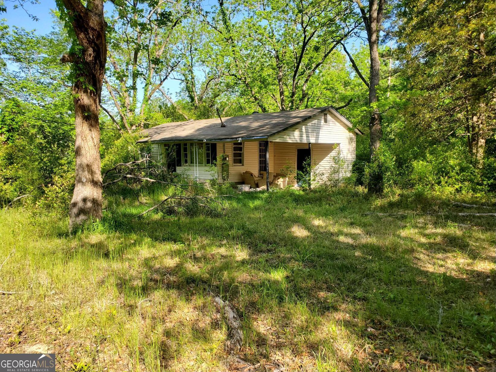 a house is sitting in middle of the forest