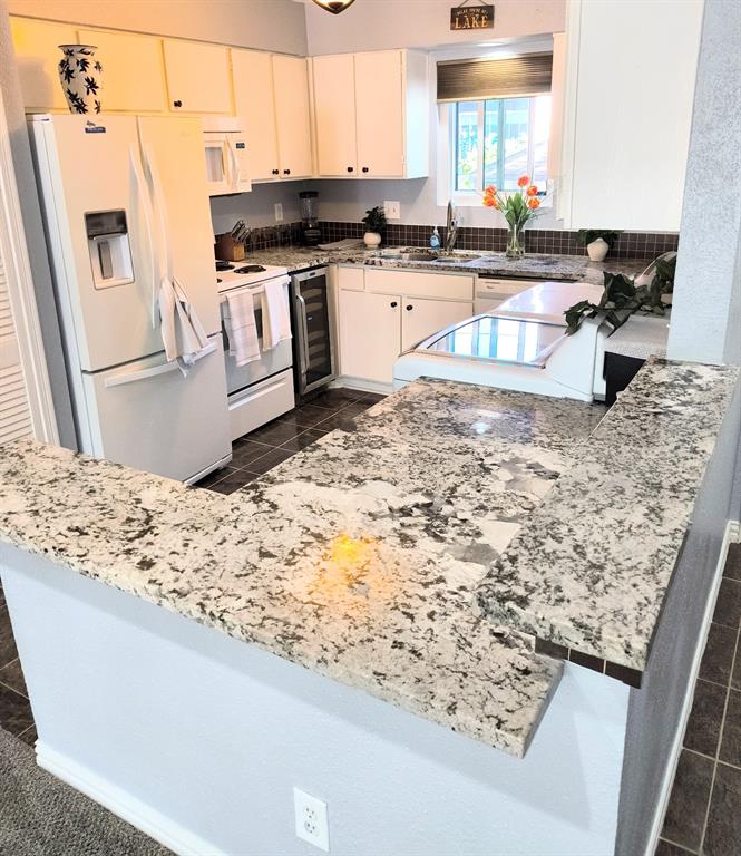 a kitchen with granite countertop a sink stove and refrigerator