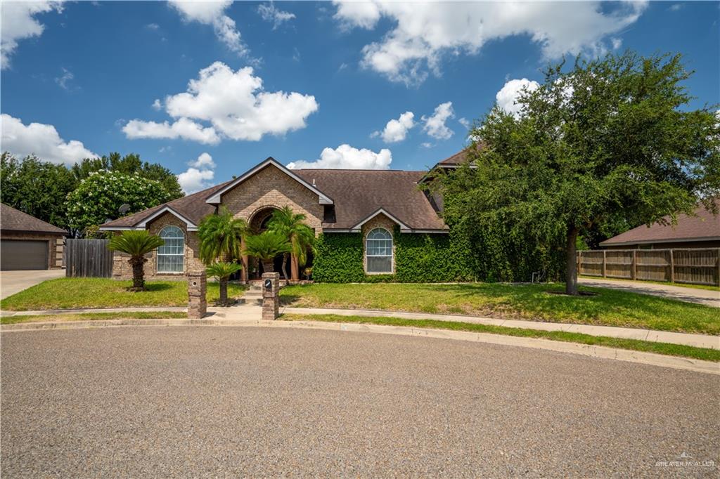 a view of a house with a big yard and large trees