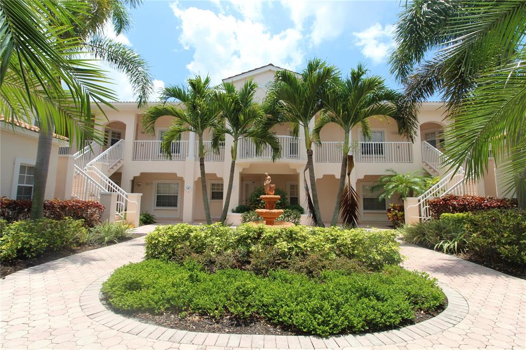 a front view of multi story residential apartment building with yard and outdoor seating