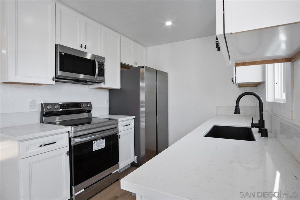 a kitchen with stainless steel appliances a stove microwave and a refrigerator