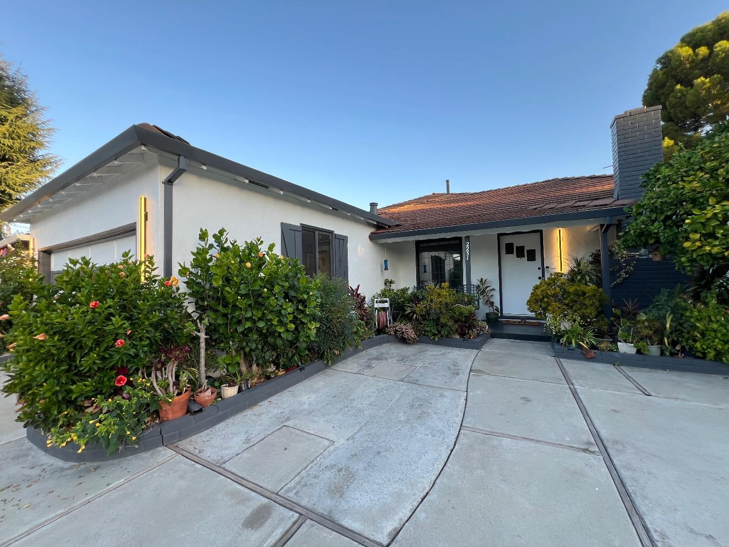 a front view of a house with plants