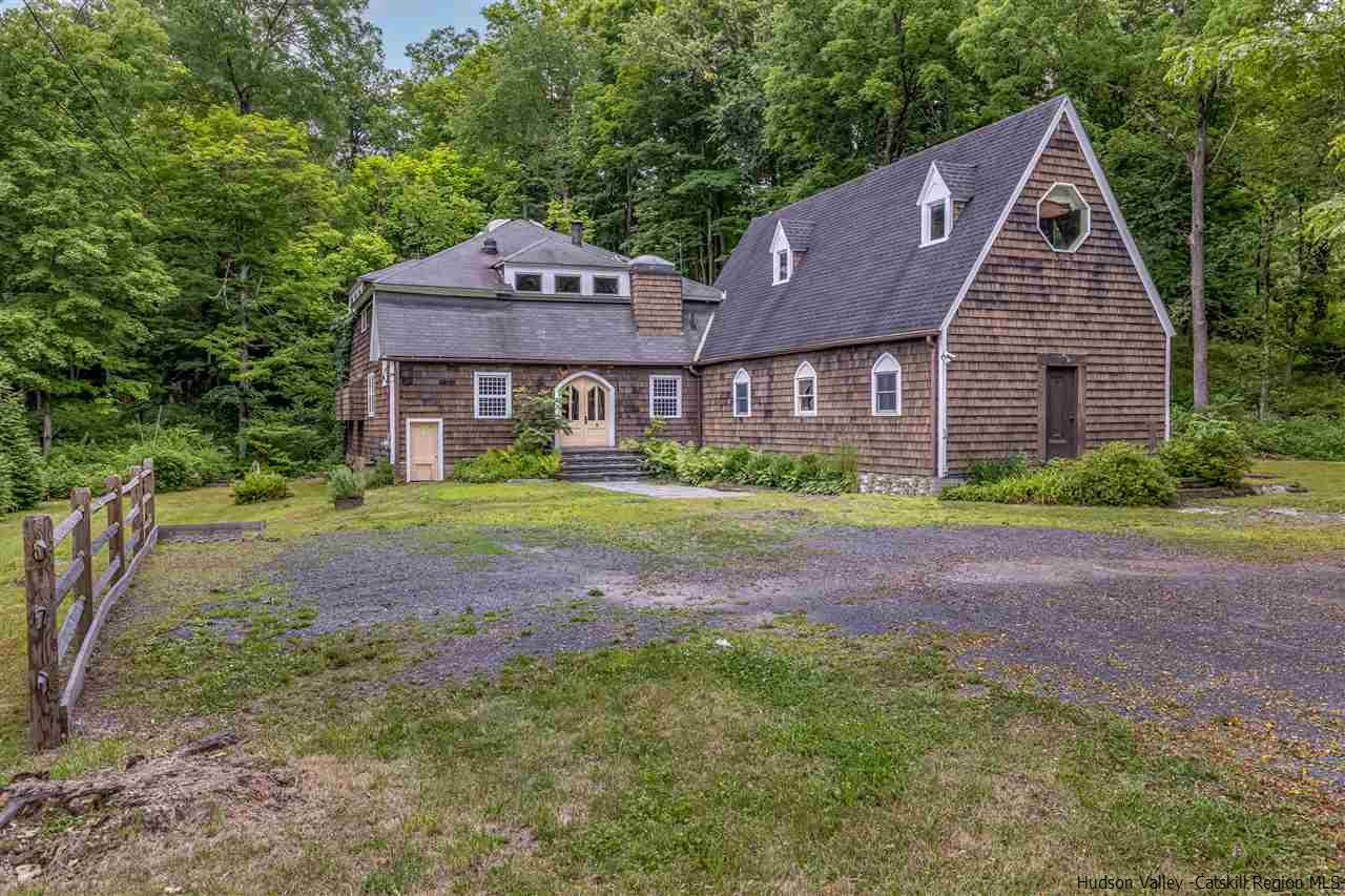 a brick house with a yard and large trees