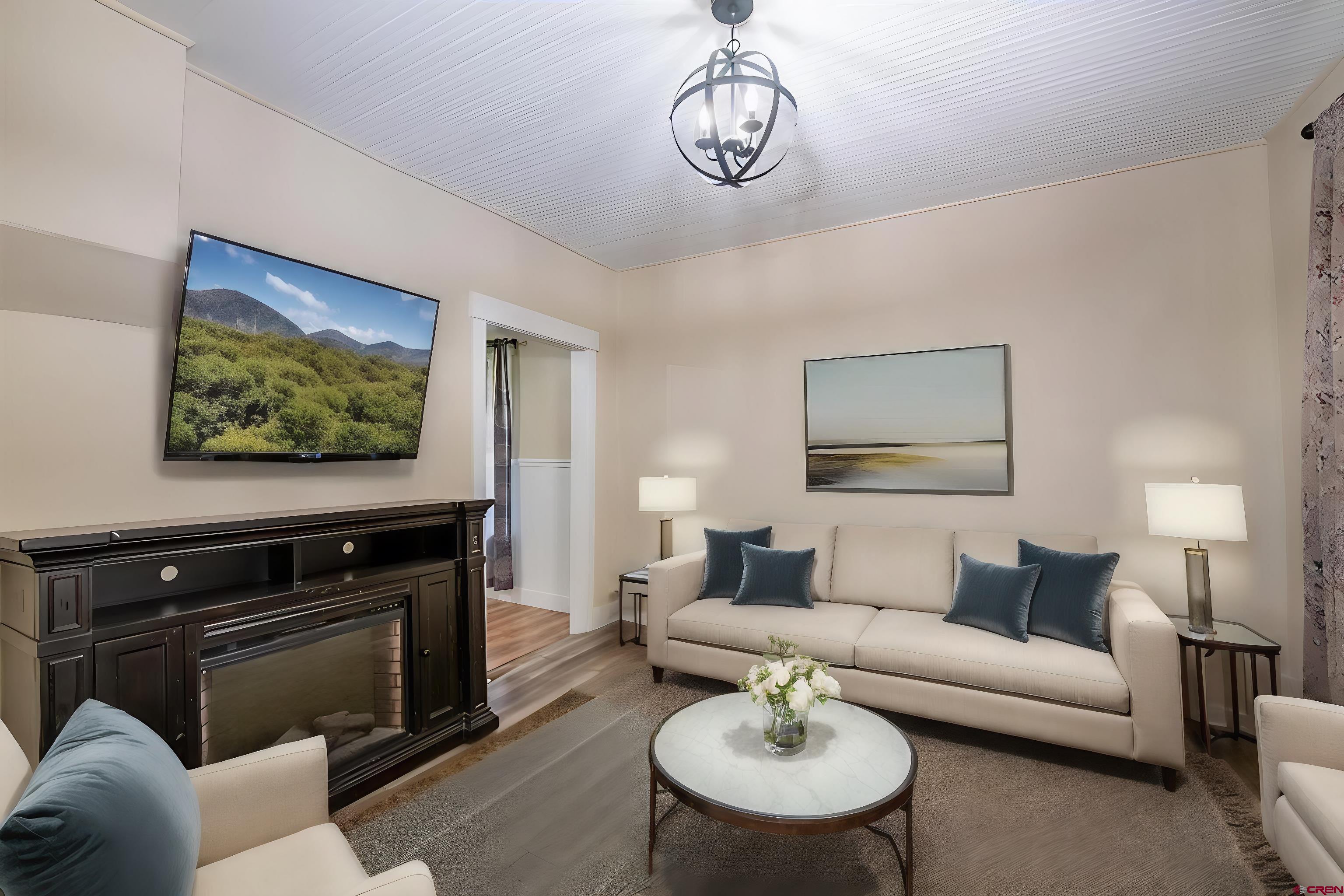 a living room with furniture a fireplace and a flat screen tv