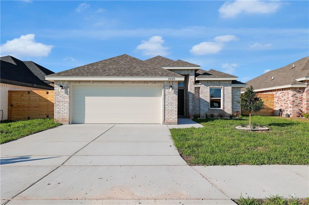 View of front of home featuring a front lawn and a garage