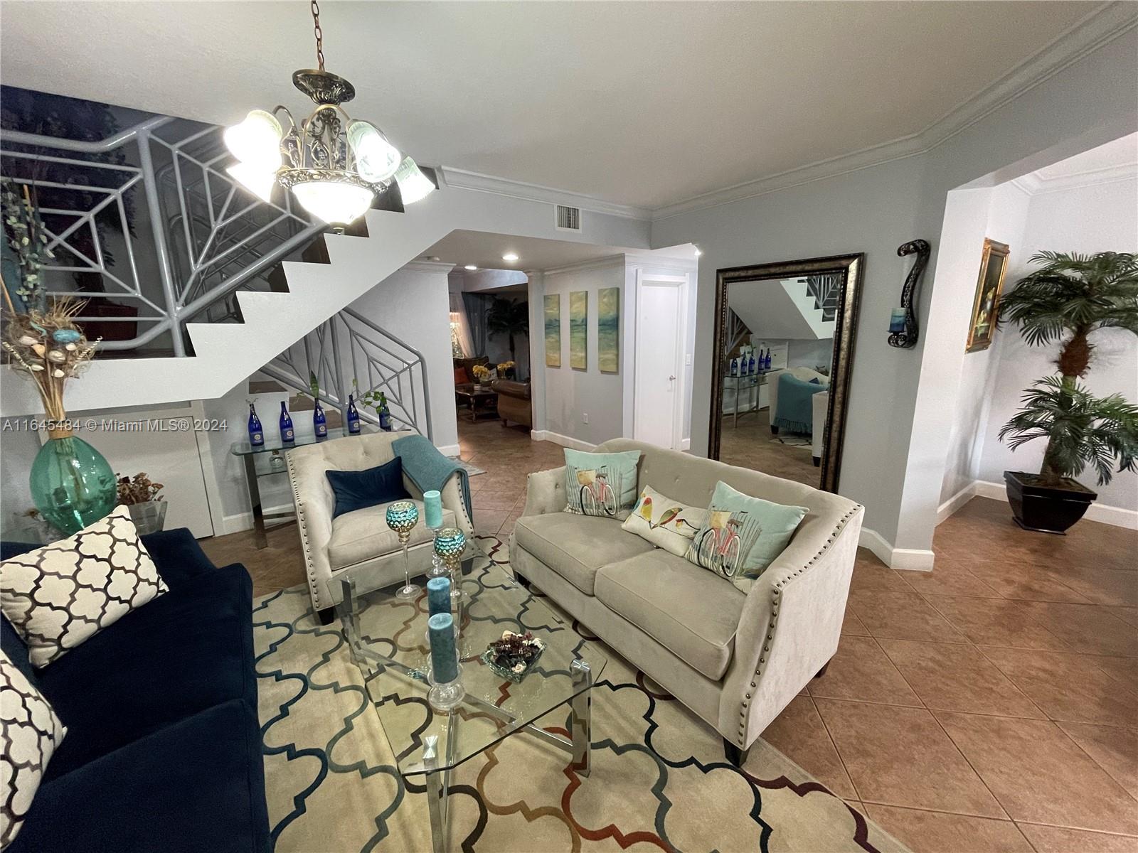 a living room with furniture a chandelier and a fireplace