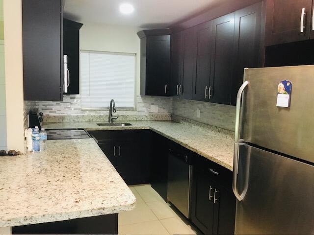 a kitchen with granite countertop stainless steel appliances and sink