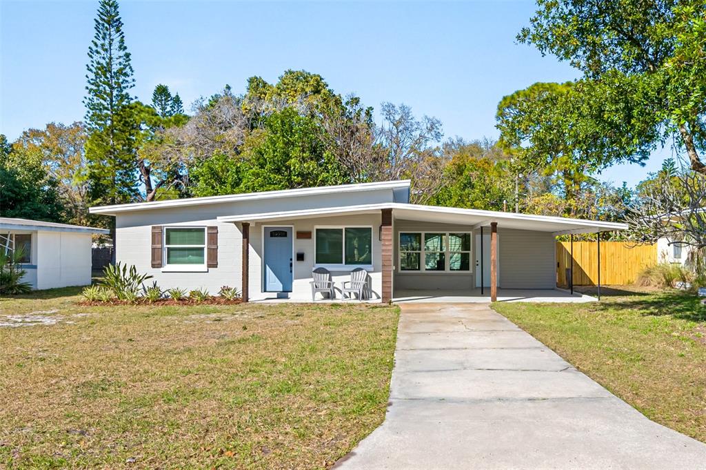 a front view of house with yard and trees in the background