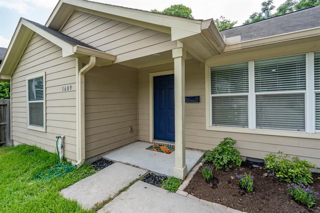 a house that has a large window and potted plants