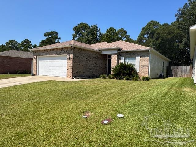 a front view of house with yard and trees in the background