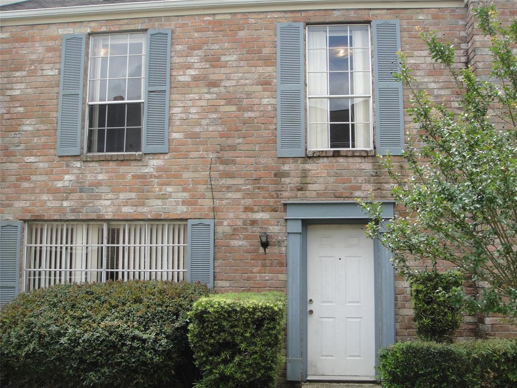 a brick house with windows and wooden walls