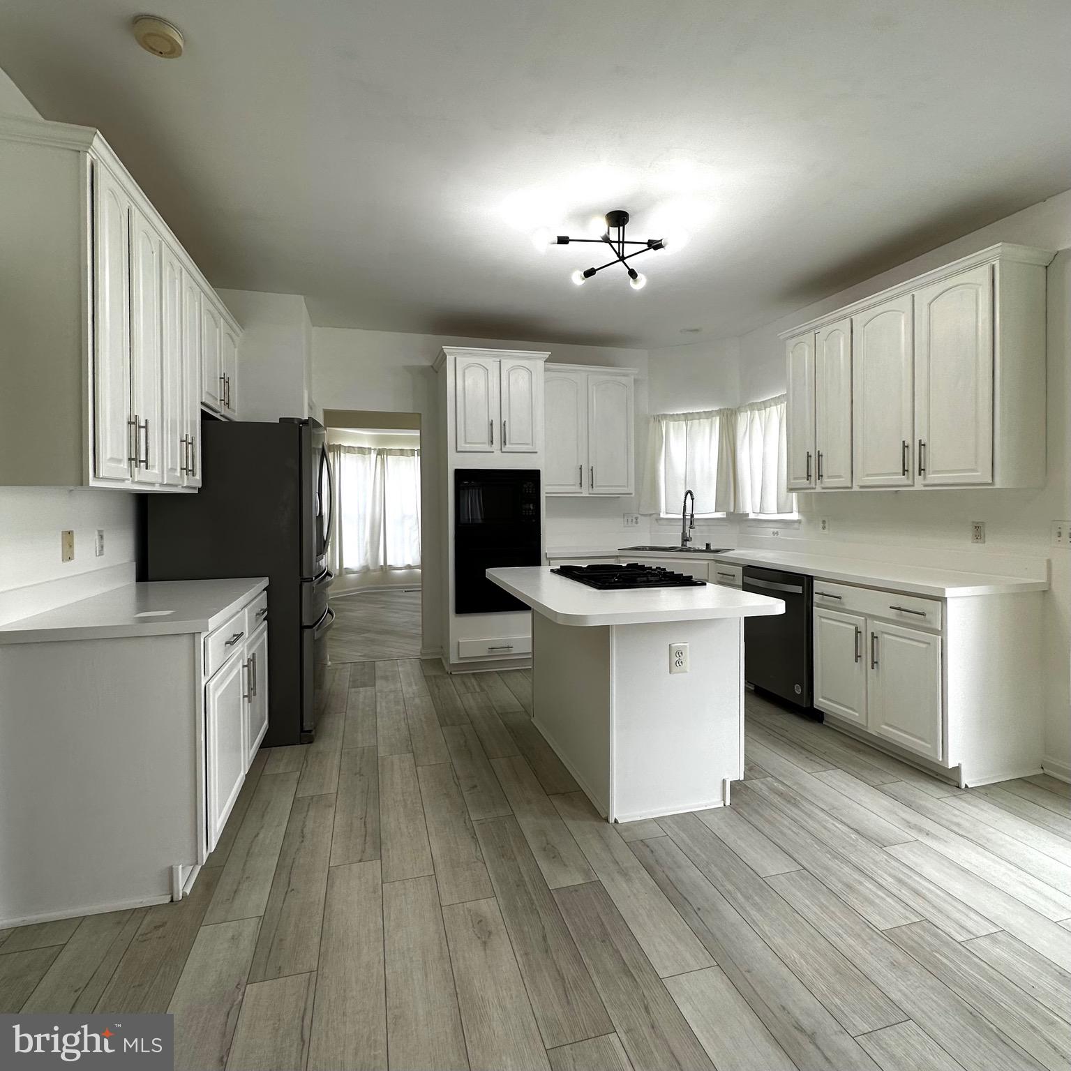 a kitchen with granite countertop a sink cabinets stainless steel appliances and a window