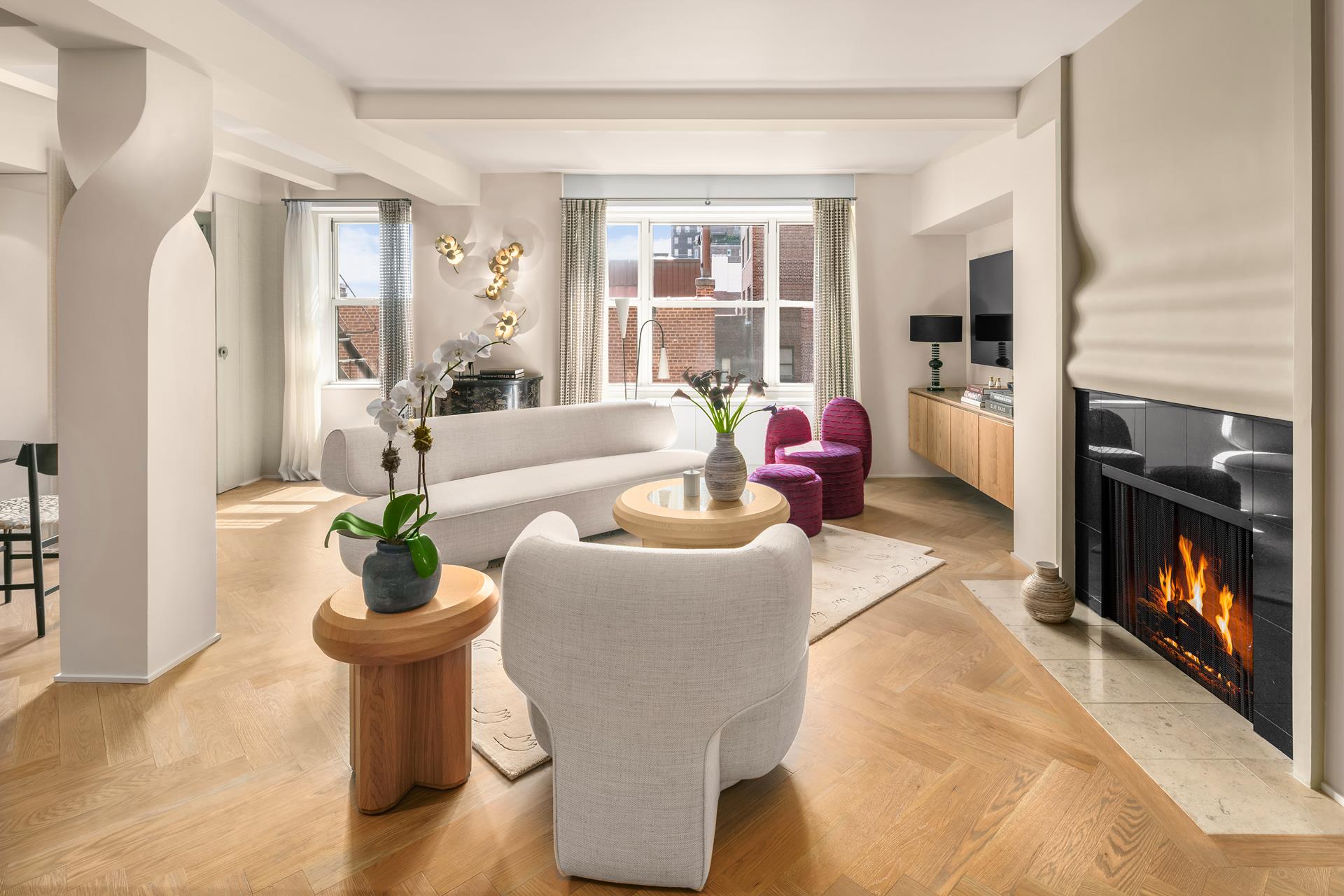 a living room with furniture a fireplace and a potted plant