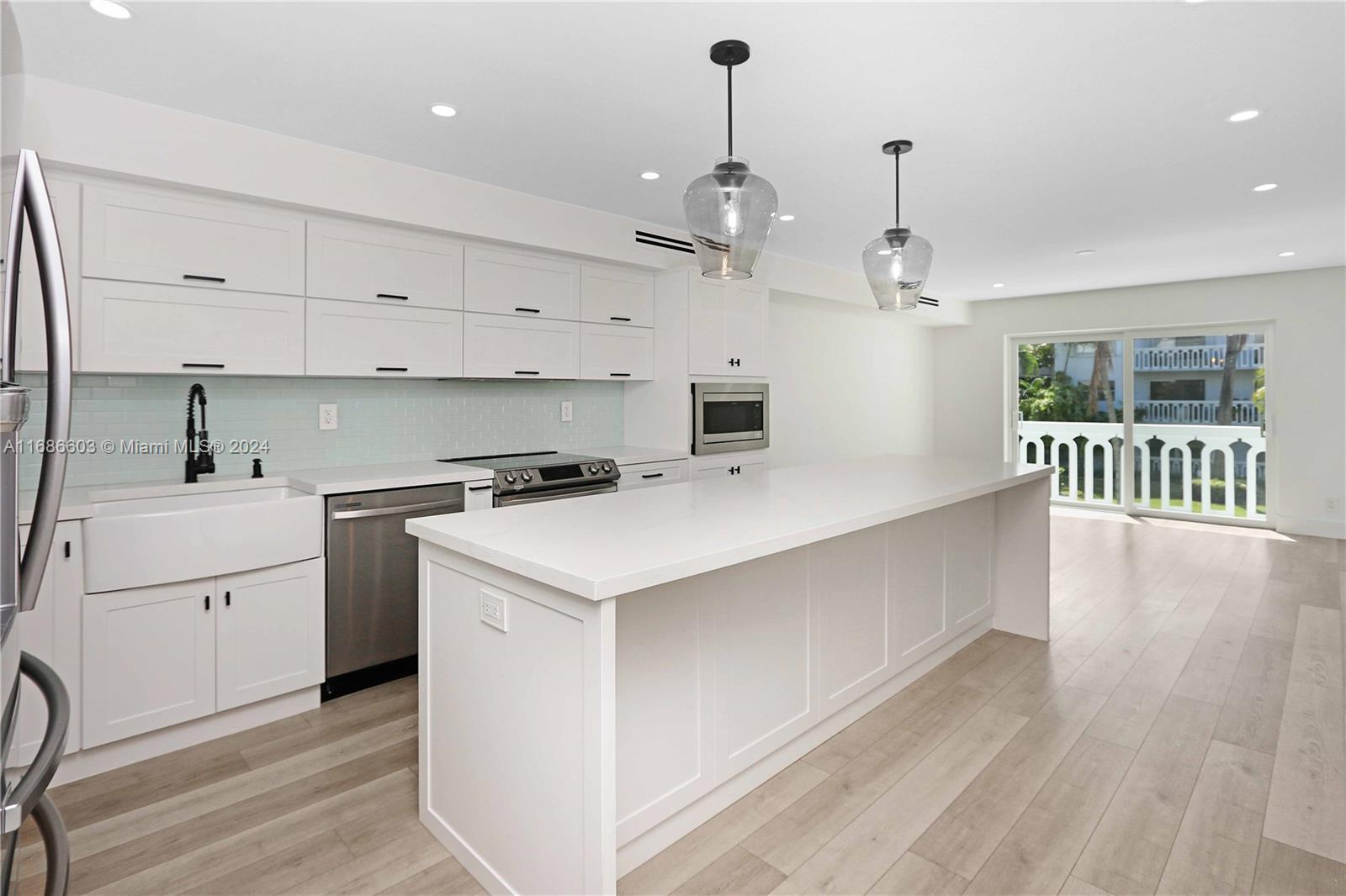 a kitchen that has a lot of cabinets in it and wooden floors