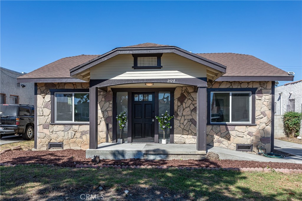 a front view of a house with a yard outdoor seating and garage