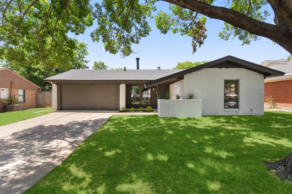 a view of a house with a yard and tree