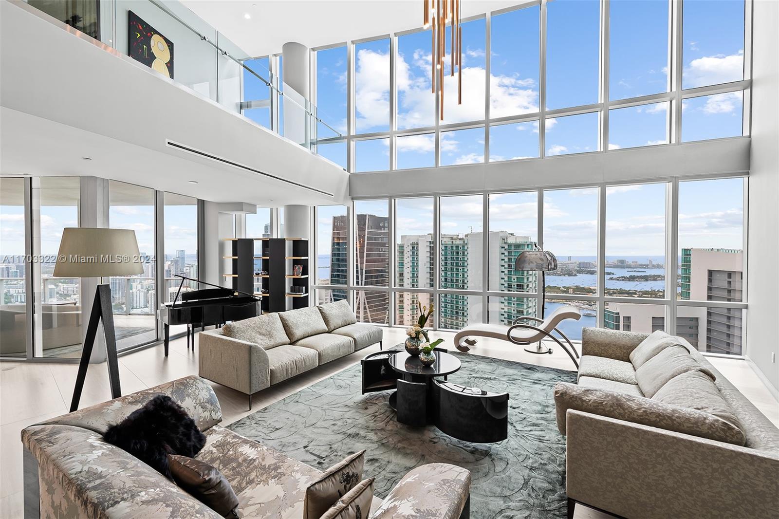 a living room with furniture wooden floor and floor to ceiling windows