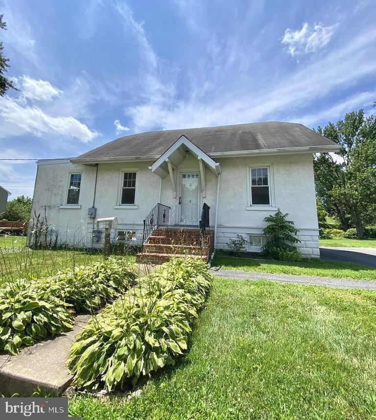 a front view of house with yard and trees around