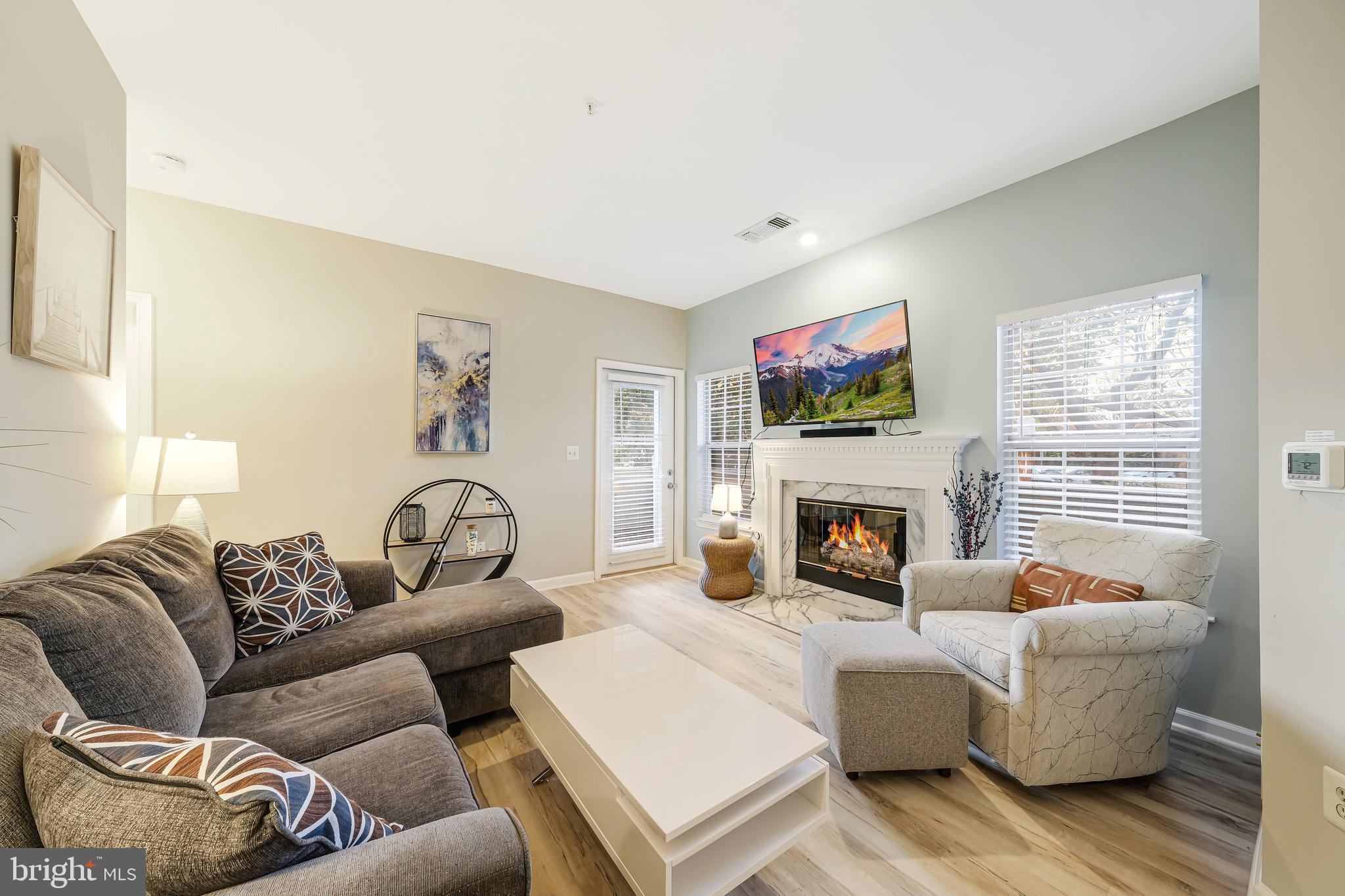 a living room with furniture a fireplace and a flat screen tv