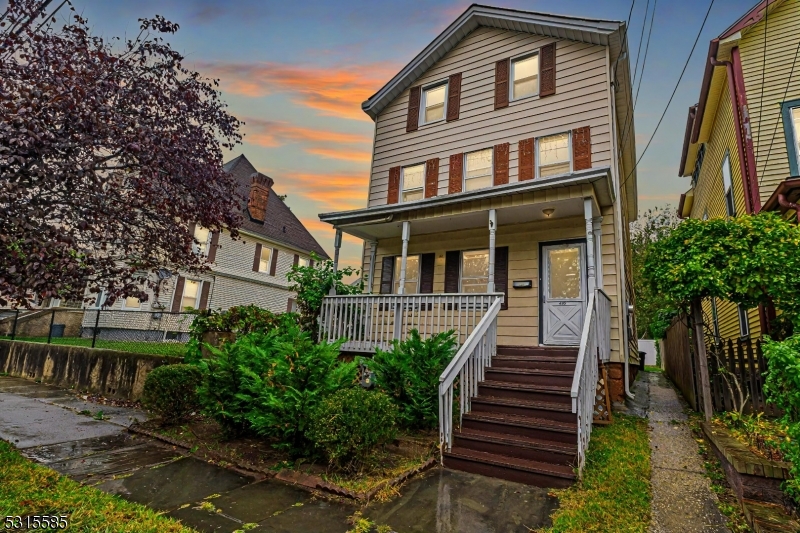 a view of a house with wooden stairs and a table and chairs