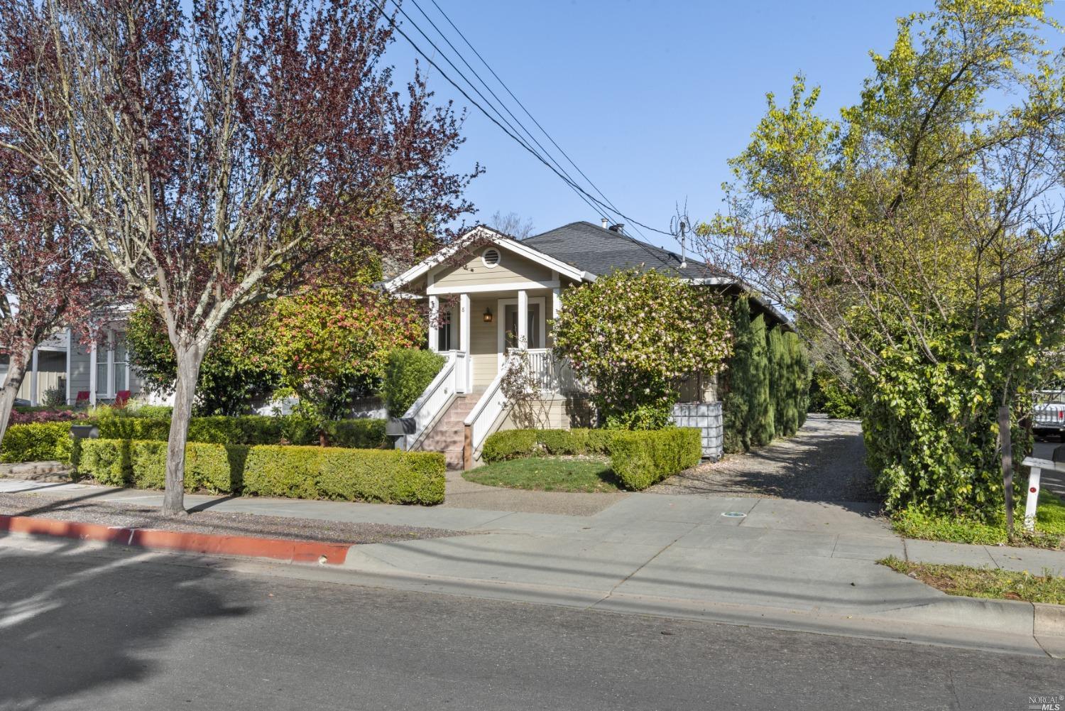 a front view of a house with a yard and potted plants