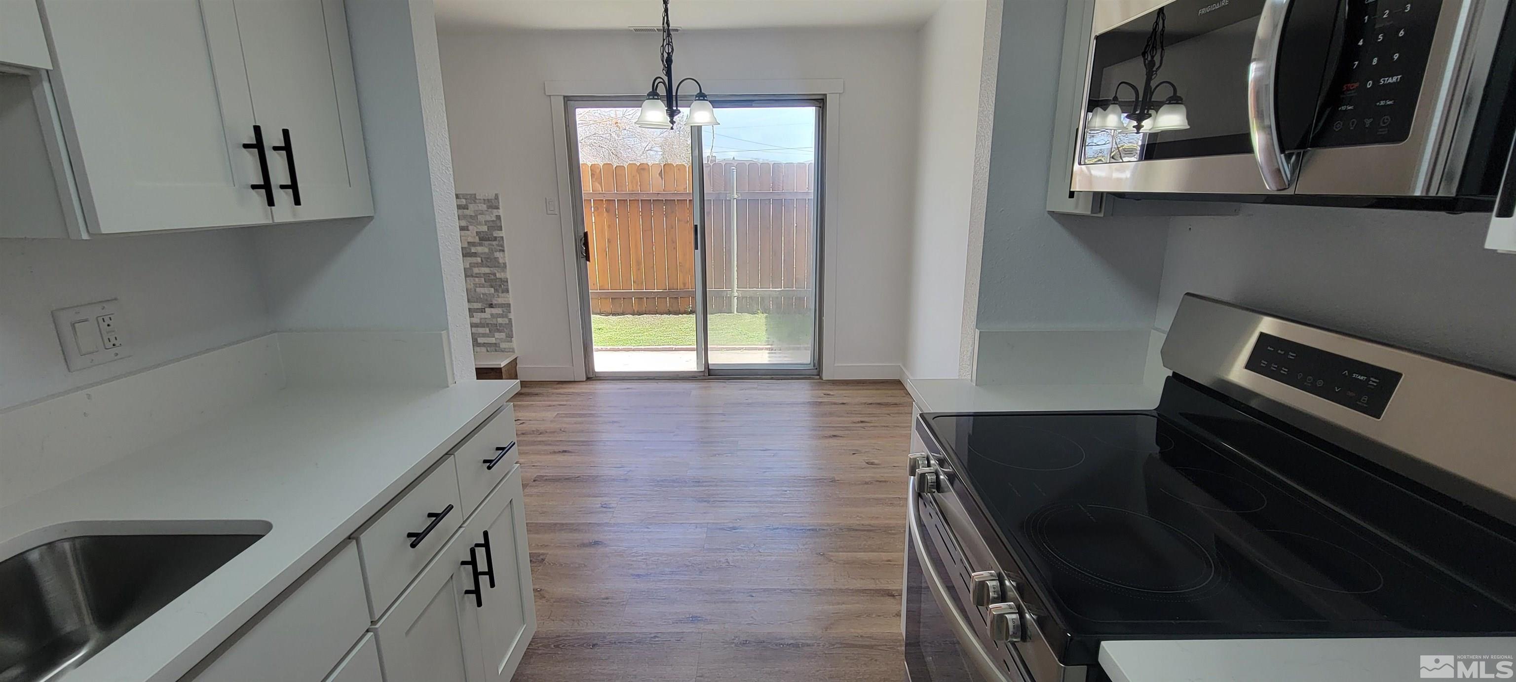 a kitchen with granite countertop a stove and a refrigerator