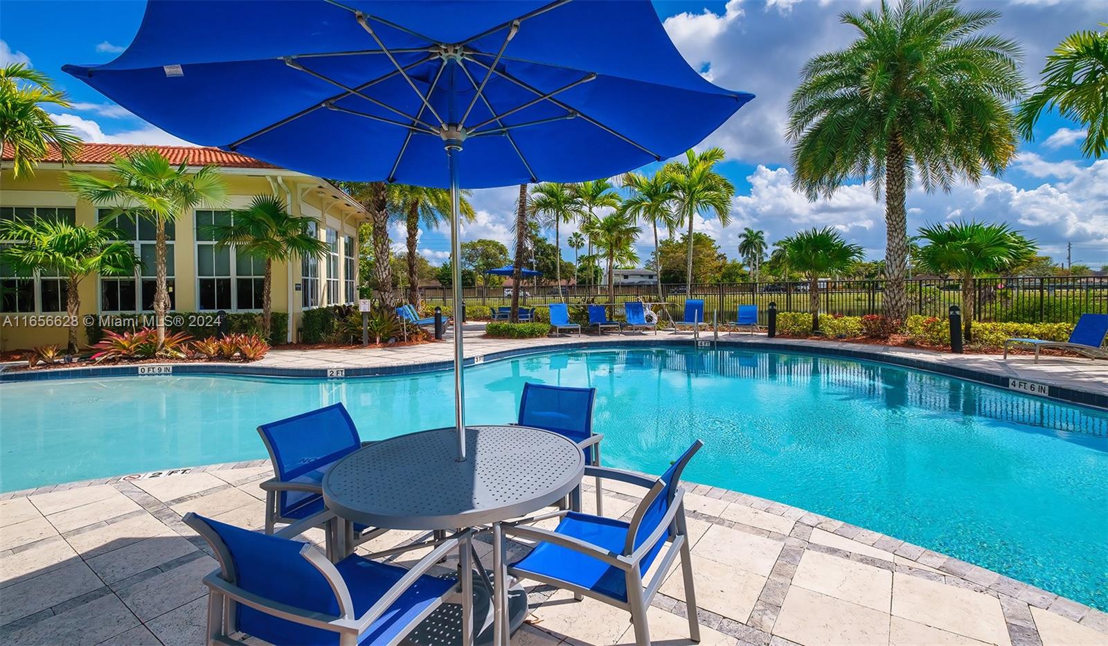 a view of a lake with a table and chairs under an umbrella