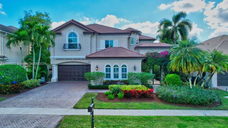 a front view of a house with a yard and potted plants