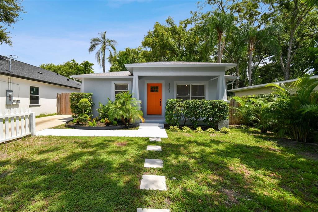 a front view of a house with a yard and potted plants