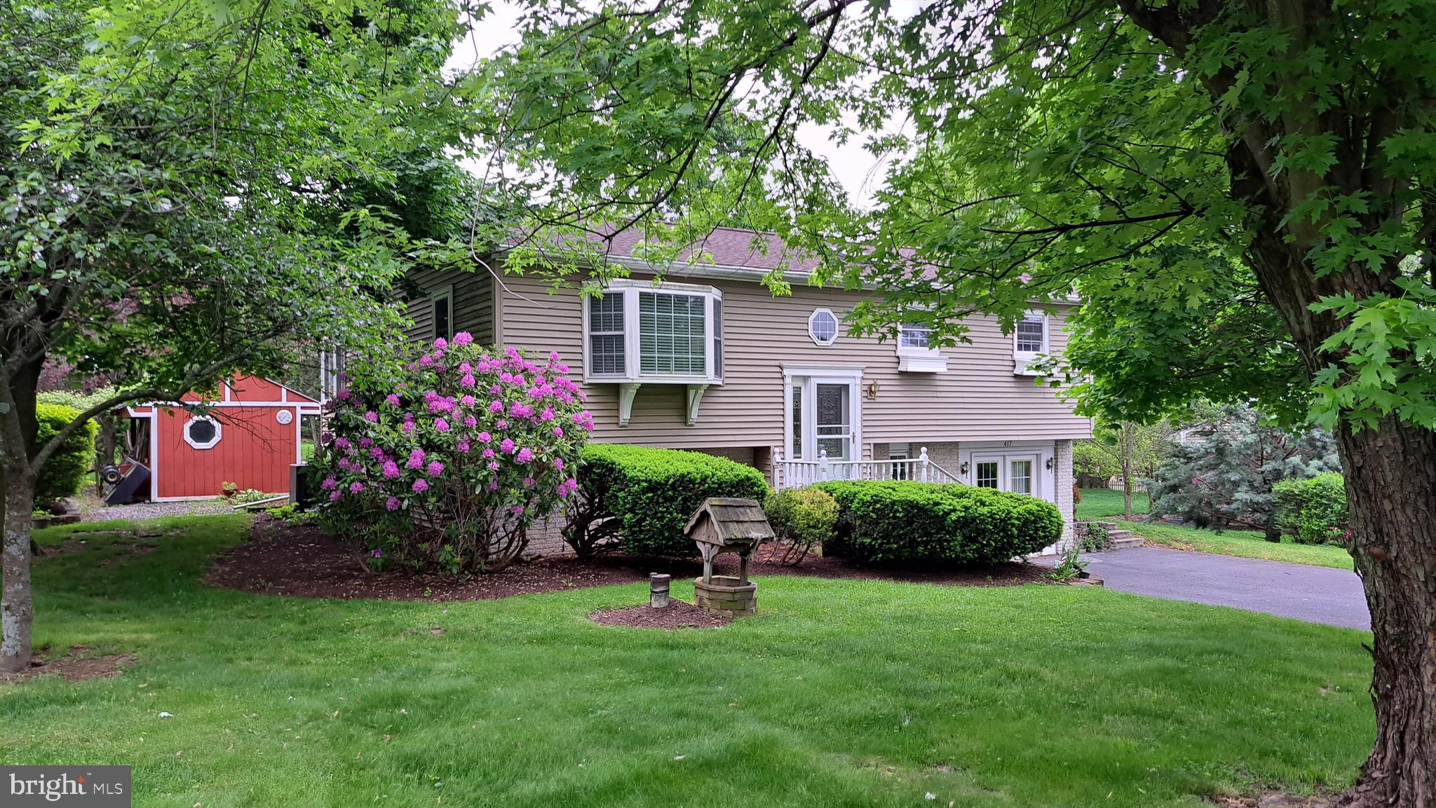 a view of a house with a yard and a tree