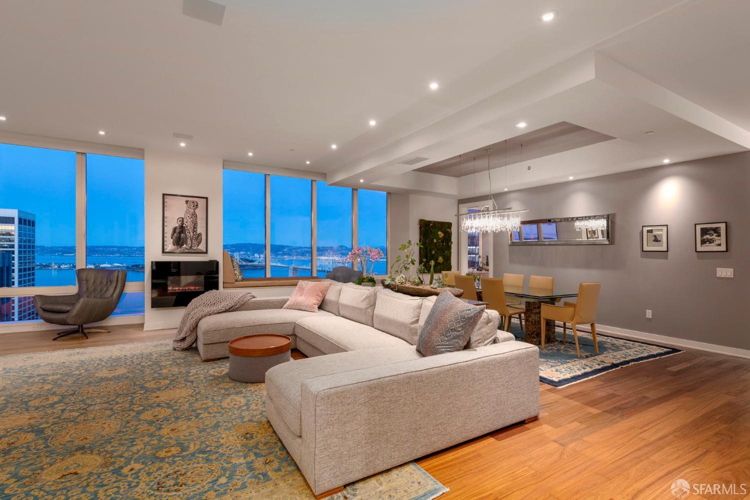 a living room with furniture kitchen view and a wooden floor