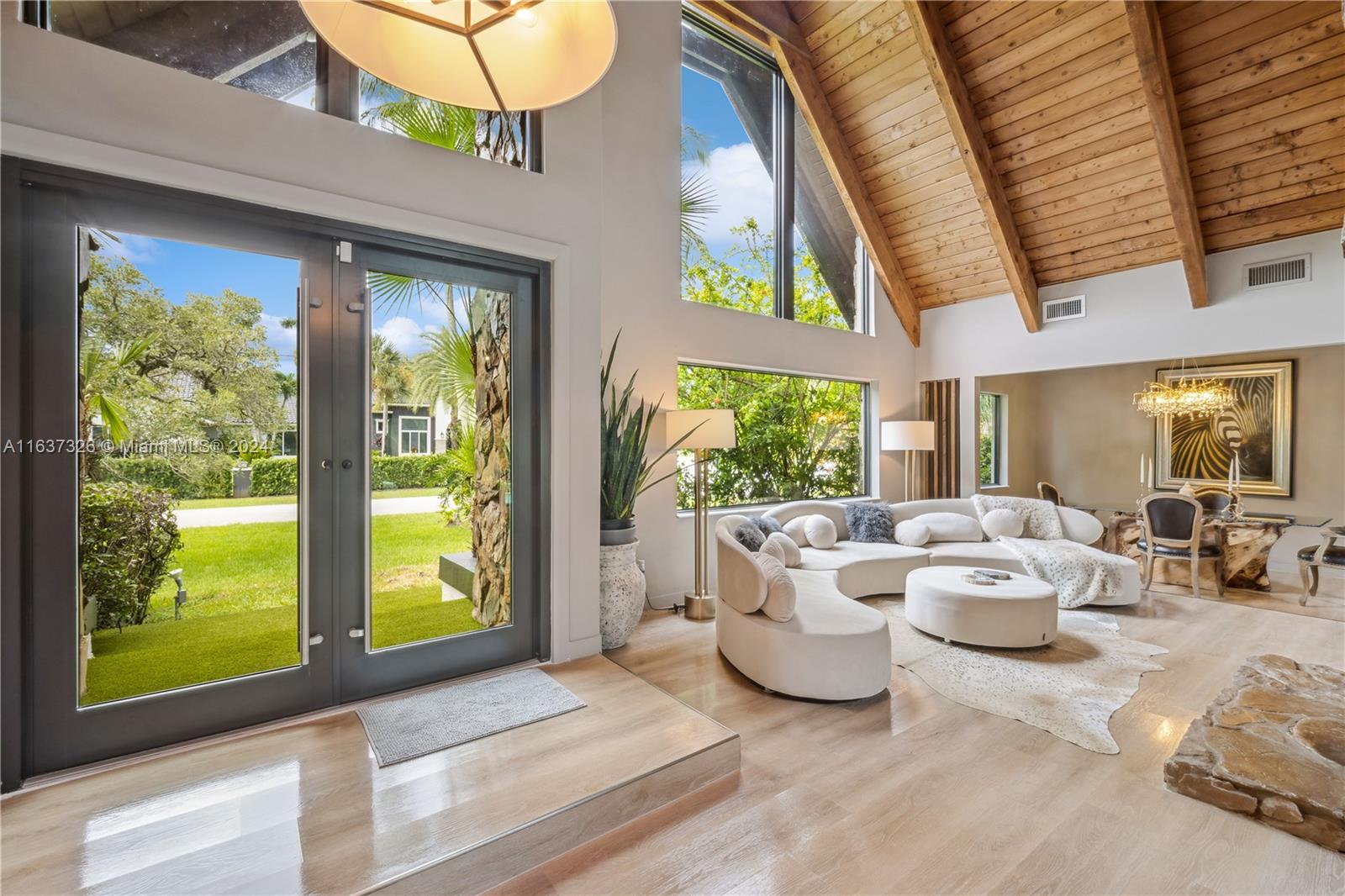 a living room with patio furniture and a large window