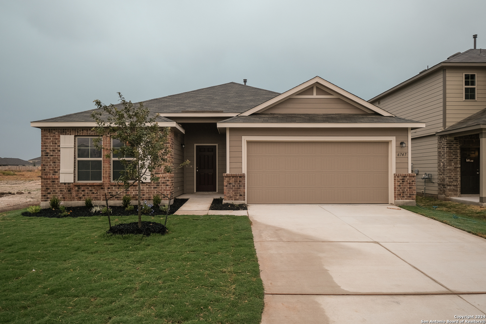 a front view of a house with a yard and garage