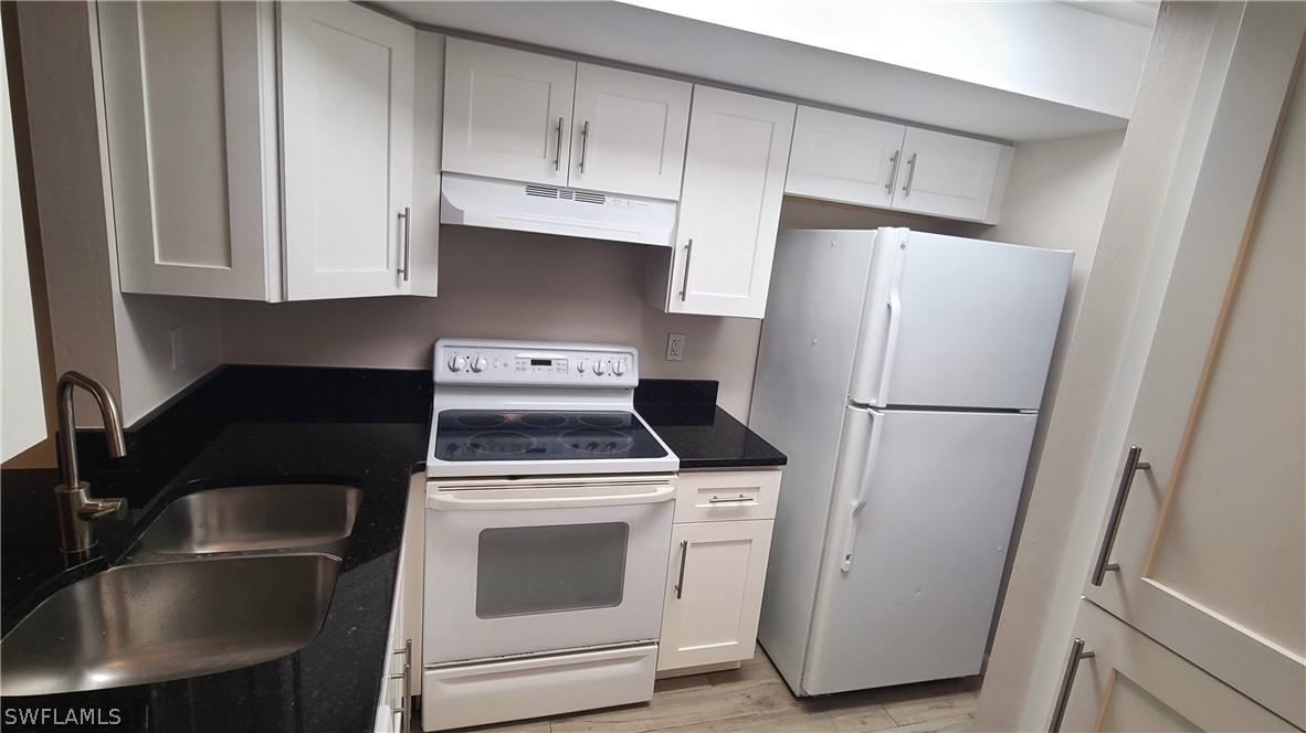 a kitchen with refrigerator a stove a sink and cabinets