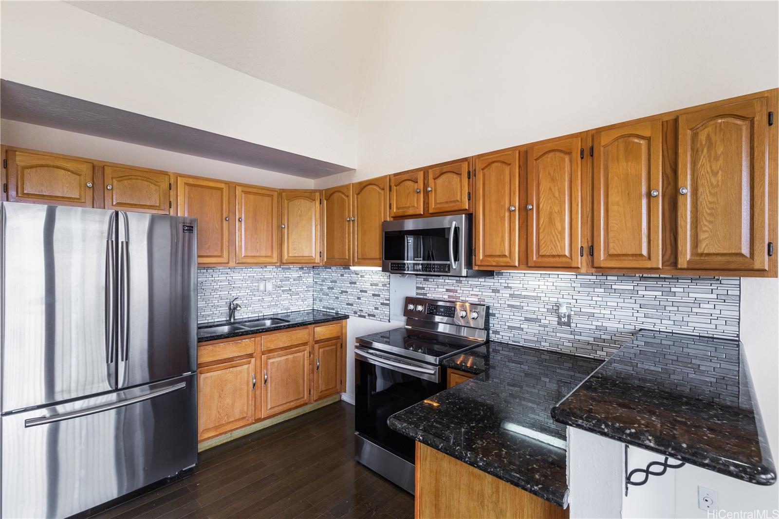 a kitchen with stainless steel appliances granite countertop a refrigerator stove and microwave