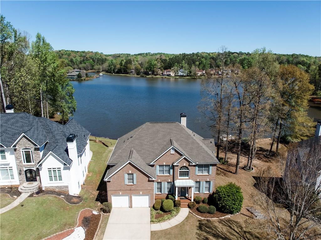 an aerial view of a house with a yard and lake view