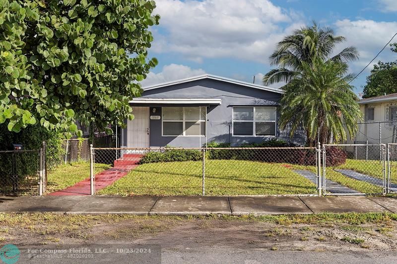 a view of a house with a yard and palm trees