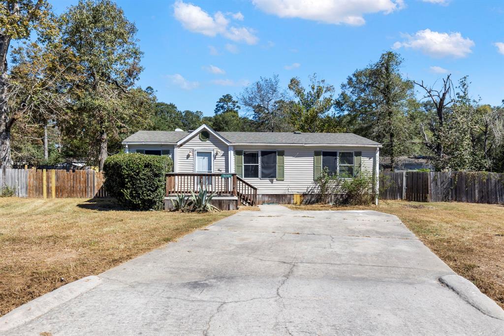 a front view of a house with yard porch and tree