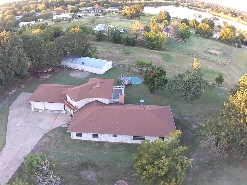 an aerial view of a house with a yard and lake view