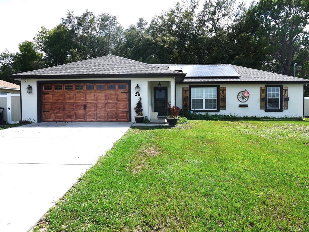 a front view of a house with a yard and trees