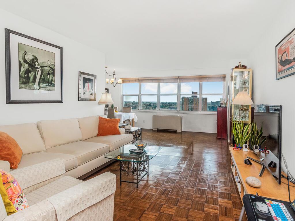 a living room with furniture a fireplace and a floor to ceiling window